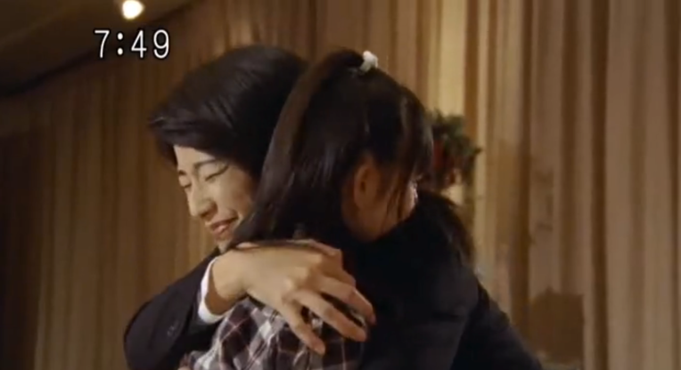 Miki embracing her daughter Natsume after helping Natsume break out of being controlled by the Unicorn-ken user.